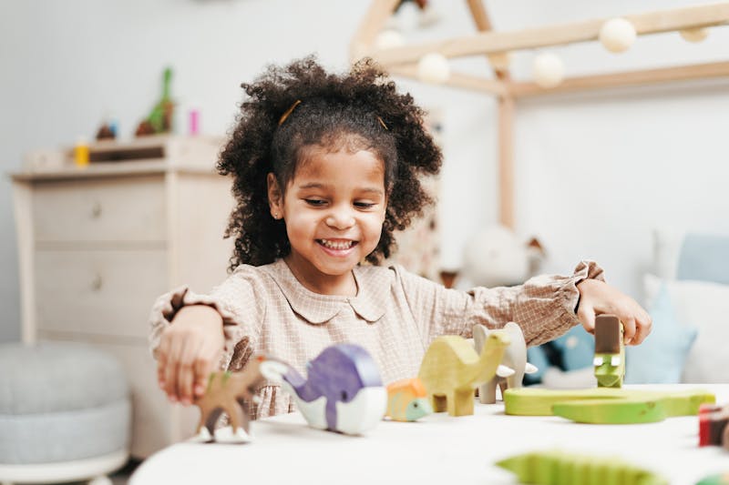 Smiling girl playing with wooden toys